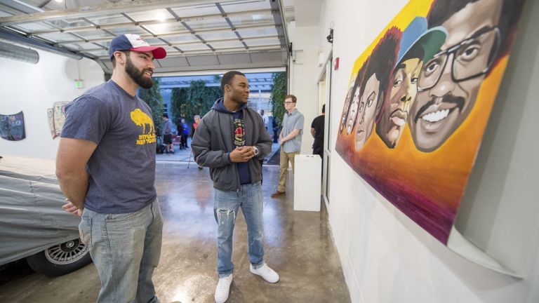 students looking at artwork on wall