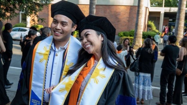 two students in graduation attire
