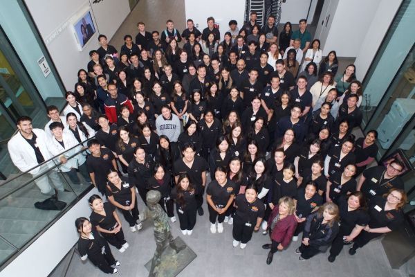 a large group of PT students are shown looking up and smiling