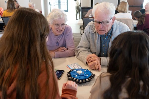 students and older people sitting at a table together