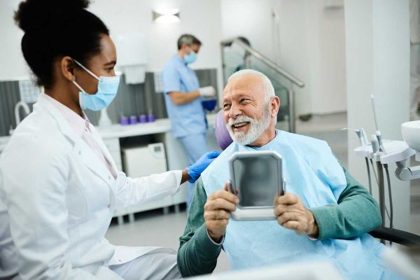 senior man with beard in clinic talking to dentist