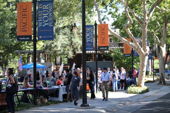 A group of students and faculty enjoy a reception outside.