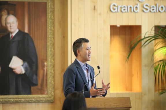 A man stands in front of a podium speaking.