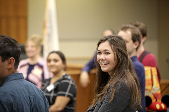 A group of law students stands in a meeting.