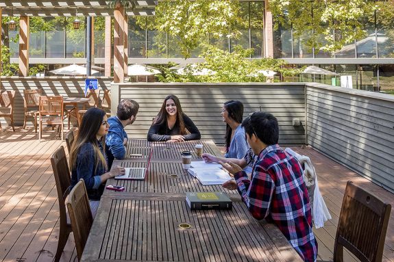 Students conversing outside on a patio 