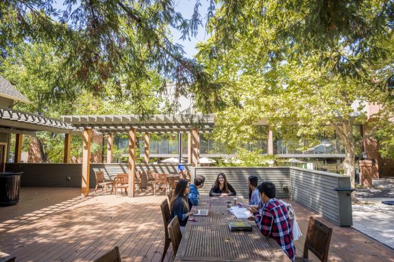 A group of law students sits at a table outside.