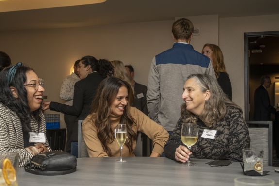 A group of law alumni and faculty sit at a table.