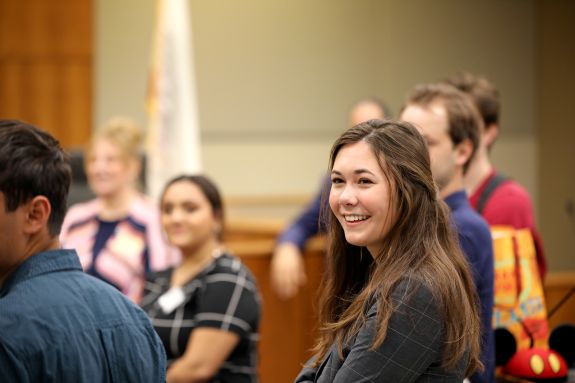 A group of law students stands in a courtroom.