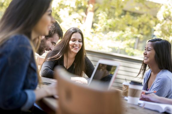 A group of law students sits at a table outside.