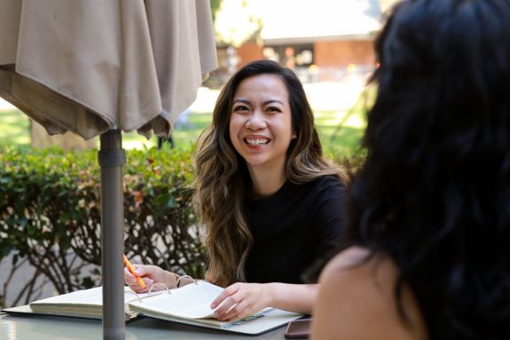 Two law students sit at a table writing.