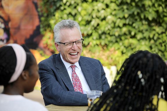 Dean Schwartz sits at a table laughing.