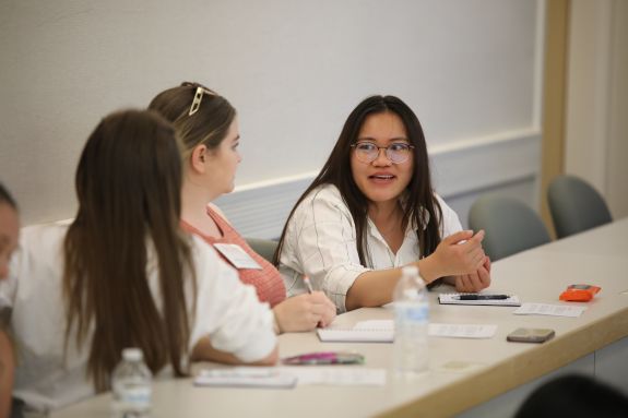 Girl in white talks with other students 