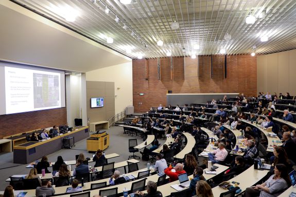 A classroom full of people listen to a lecture