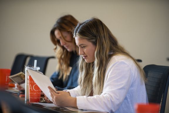 Girl in white shirt looks at a paper 