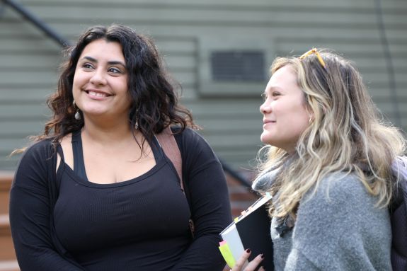 Two law students stand outside talking.