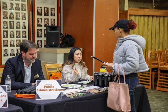 two staff members at a table help a student