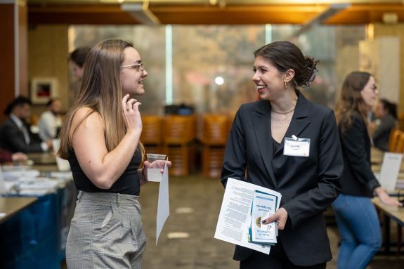 Two law students stand talking.