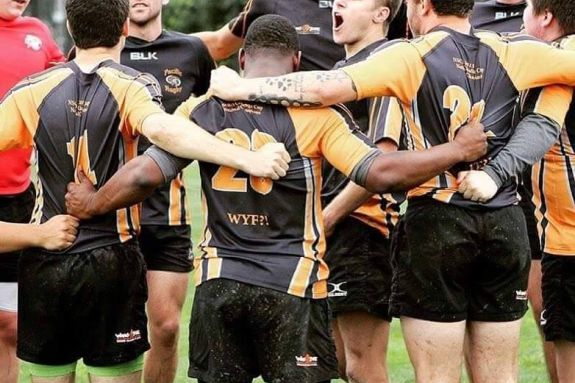 Rugby players hugging on field