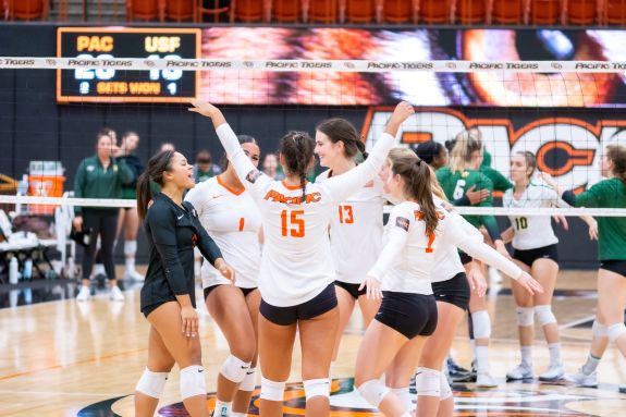 Volleyball players hugging on court