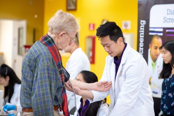 Student taking patient's blood pressure.