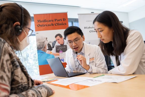 Two pharmacy students talking into a small microphone.