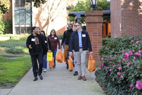 A student leads a tour group on campus