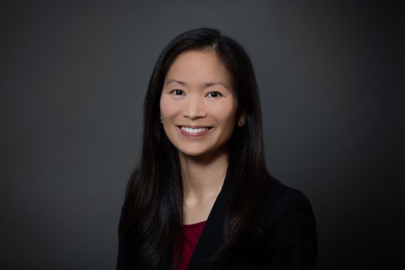 A portrait of a woman in front of a gray background  