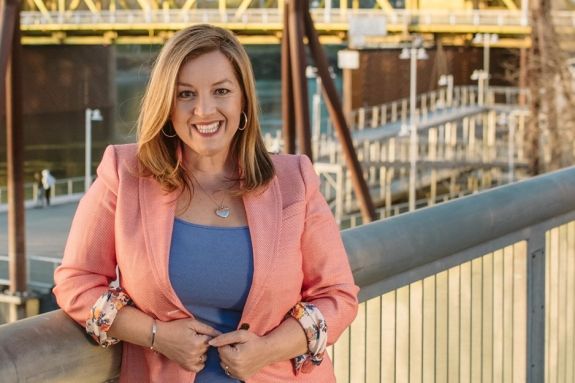 A portrait of a woman wearing a pink blazer
