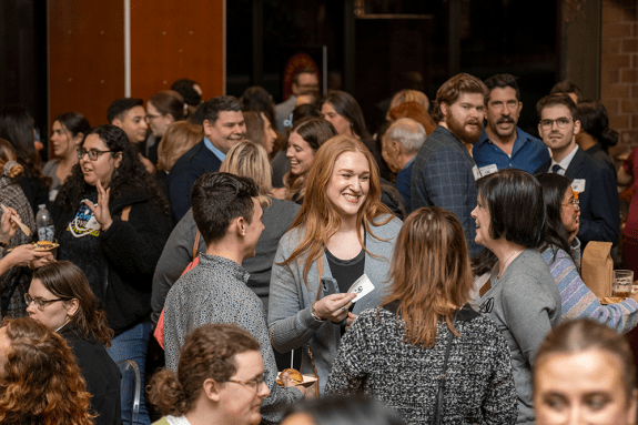 Group of people talking in a crowded room.