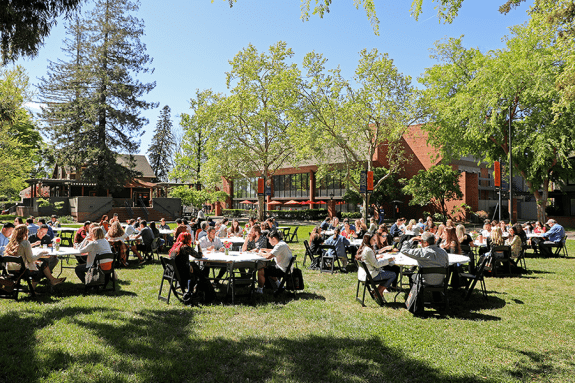 McGeorge School of Law quad. People are sitting at round tables.