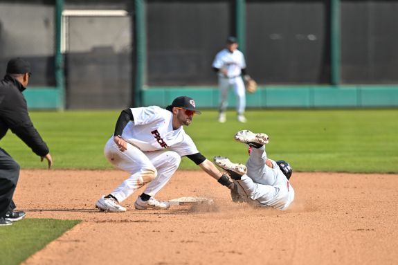 Pacific baseball player tags a runner out at second base.