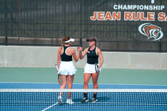 Women's tennis high fives after play