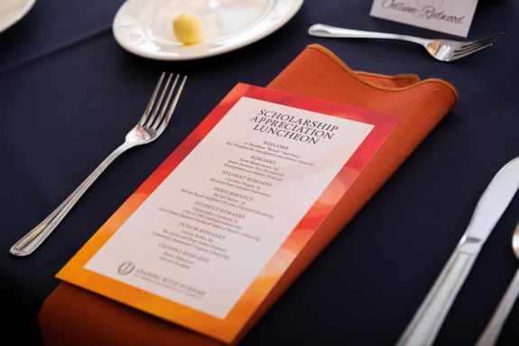 orange napkin with menu on dark blue linen