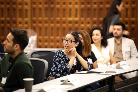 LLM students look behind them at their professor teaching