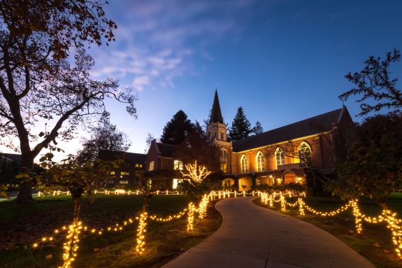 A lit up walkway leading to Morris Chapel at night.