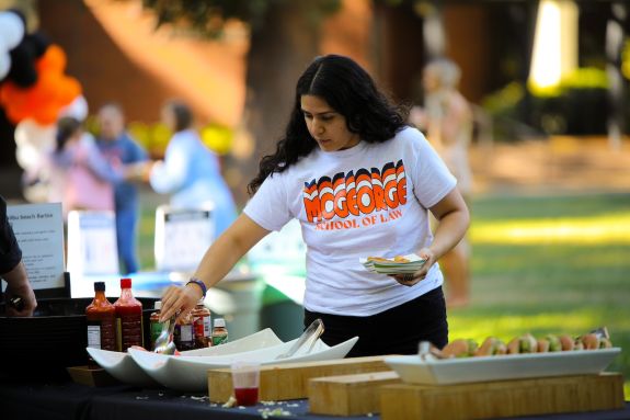 Girl in white t-shirt with blue and orange wording gets food
