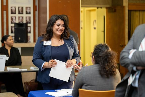 A woman speaks to a potential employer at a job fair
