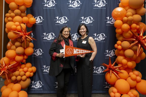 Two women hold an orange flag