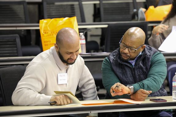 two gentlemen look over a provide info paper.