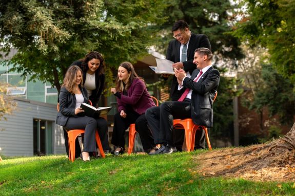 Students sitting on orange chairs conversing 
