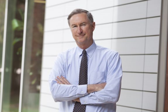 man in button up shirt and tie taking a headshot photo.