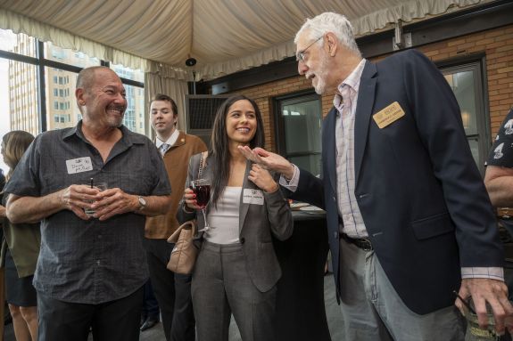 Three individuals talk with each other