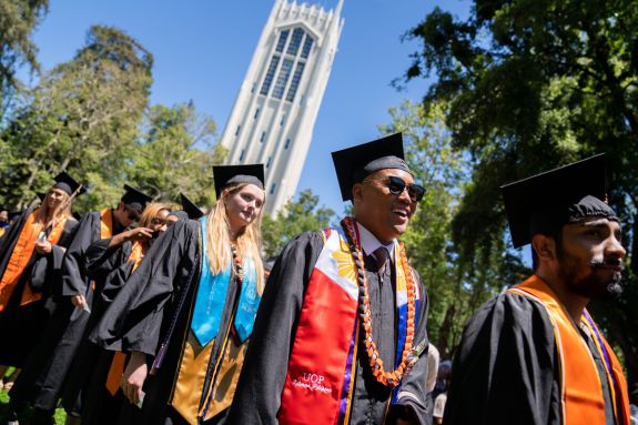 Students in regalia lined up with Burns Tower in background