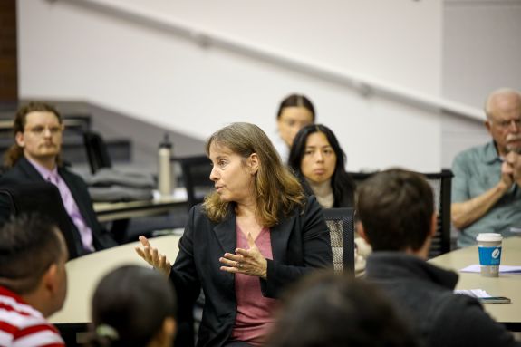 Speaker explaining a topic to an engaged audience of students.