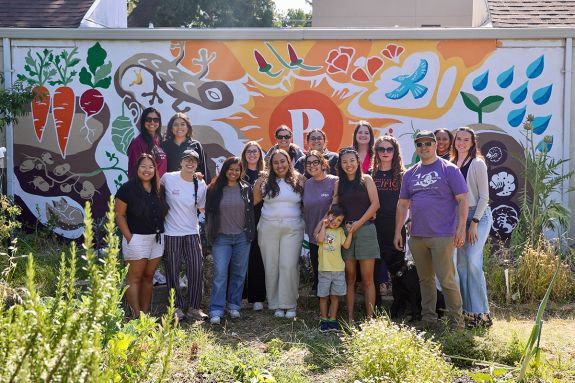 A group of about 15 people pose for a photo in a garden
