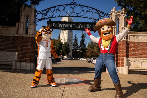 Powercat and Sourdough Sam pose for a photo in front of the entrance to University of the Pacific's Stockton Campus.