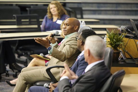 A panelist talks in a lecture hall. 