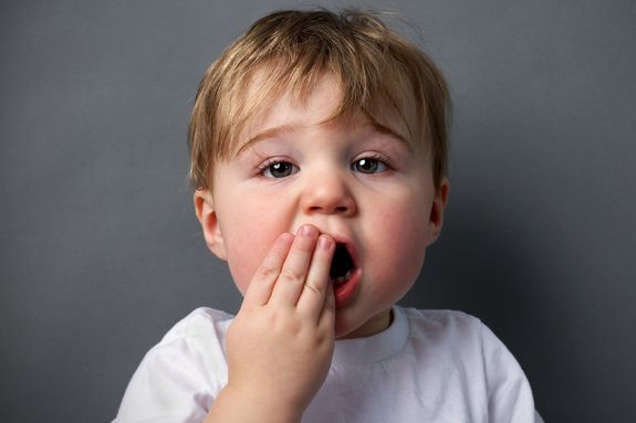 Child with hand over mouth