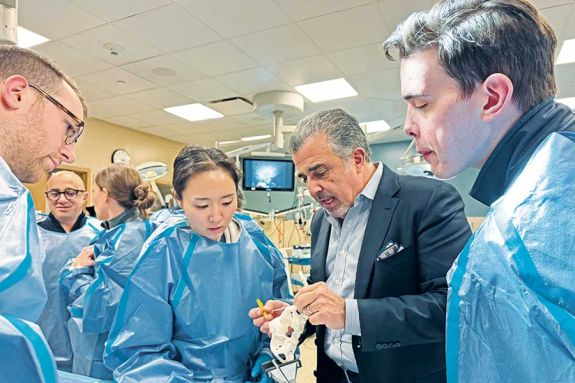 students gathered next to a male professor looking at a jaw