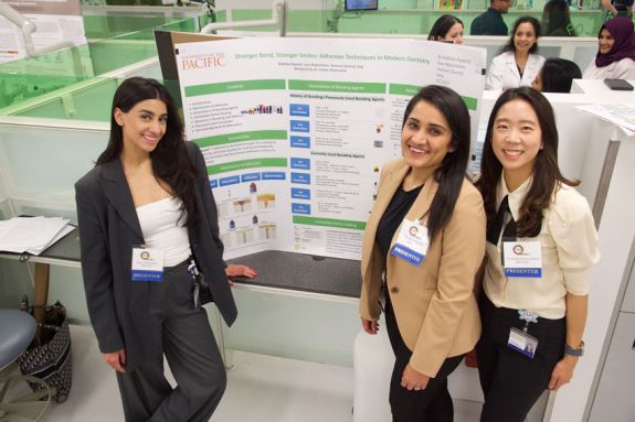 Three women with name tags reading "presenter" in front of their presentation for Excellence Day in 2024